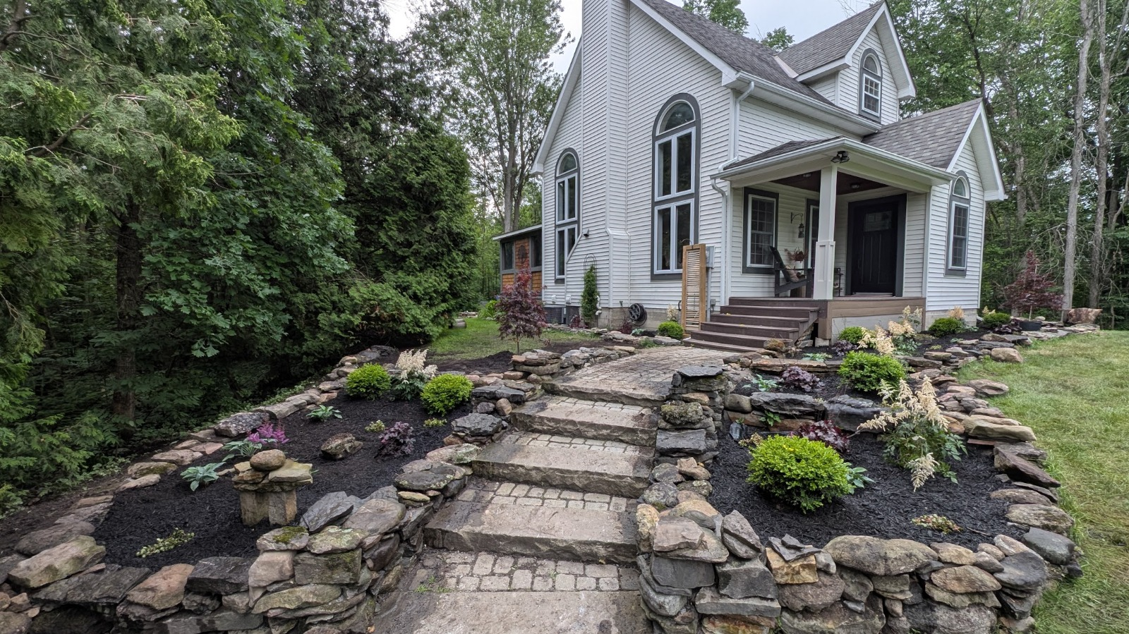 Natural stone walkway, steps and garden beds in front of a home in Cornwall, Ontario